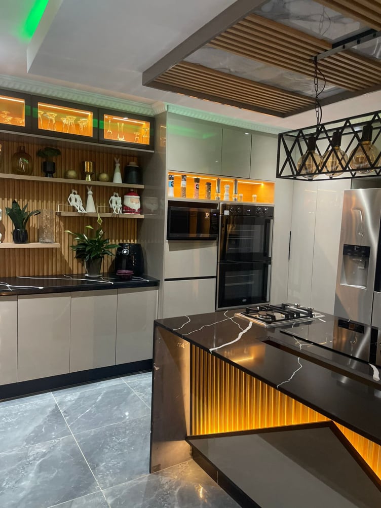 Dark kitchen island with LED toe-kick and display shelving