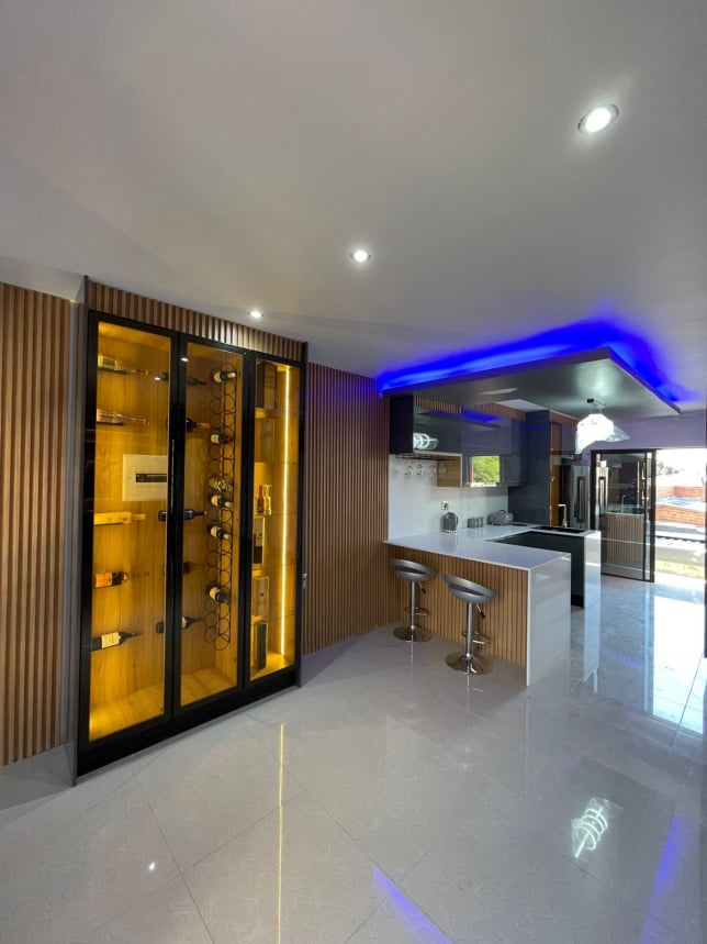 Kitchen with LED wine display and slat wall