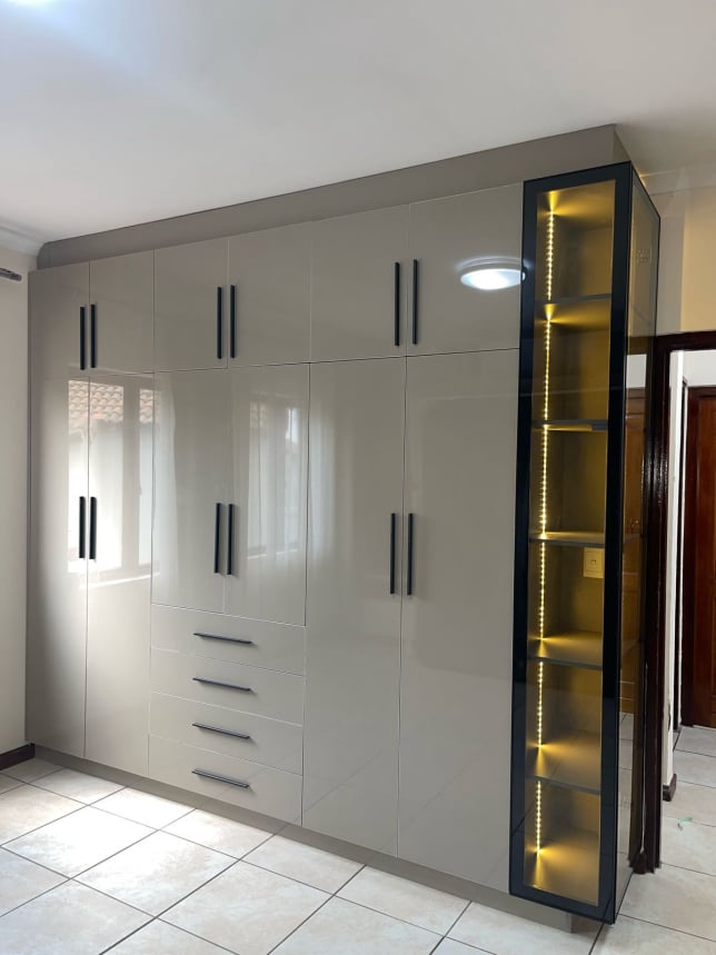 High-gloss built-in wardrobe with LED glass display tower