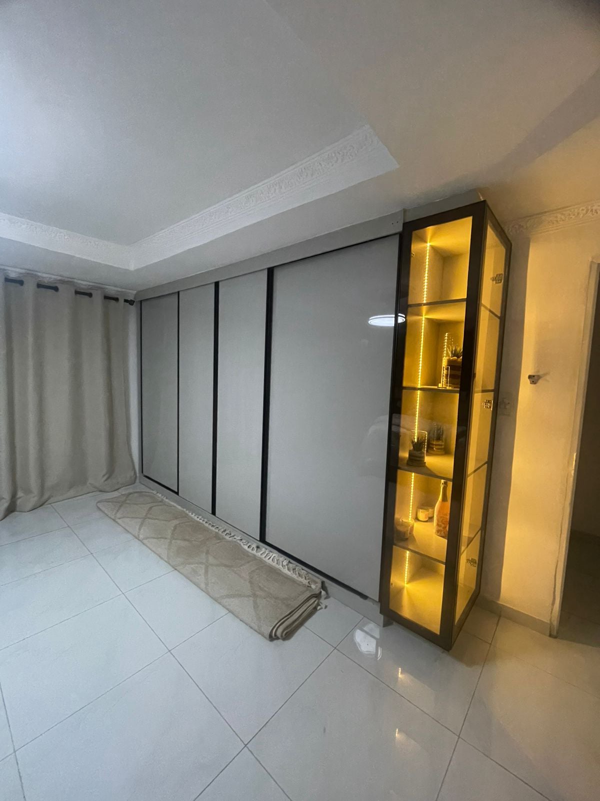 Full-wall sliding wardrobe with LED display cabinet